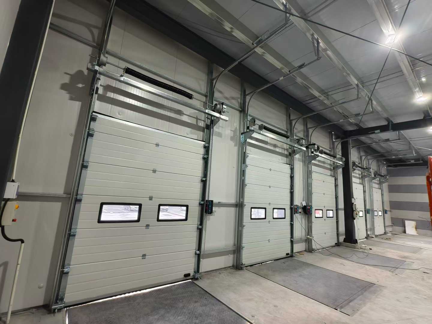 वेअरहाऊस प्रकल्पांसाठी औद्योगिक विभागीय दरवाजे आणि डॉक लेव्हलर्स शिपमेंट